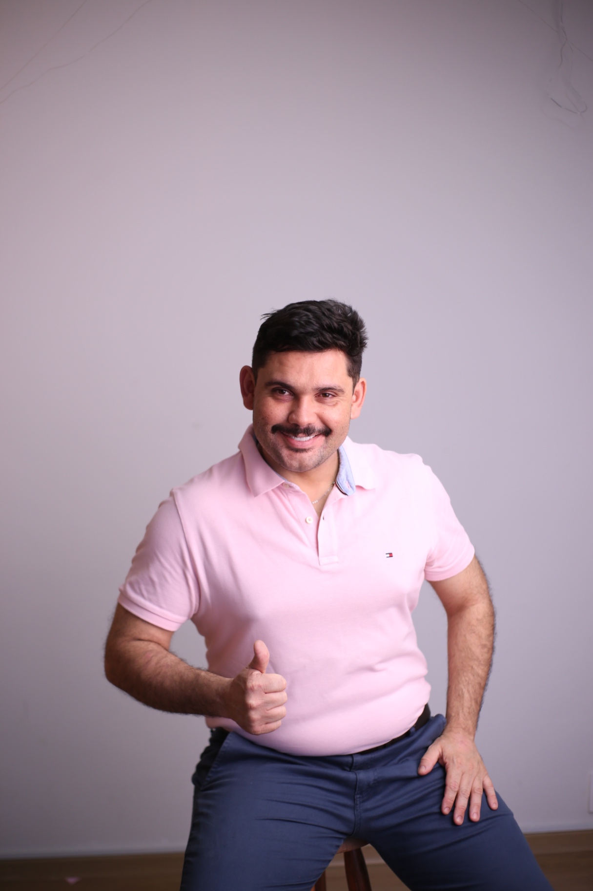 Caio apontando para a frente, sorrindo