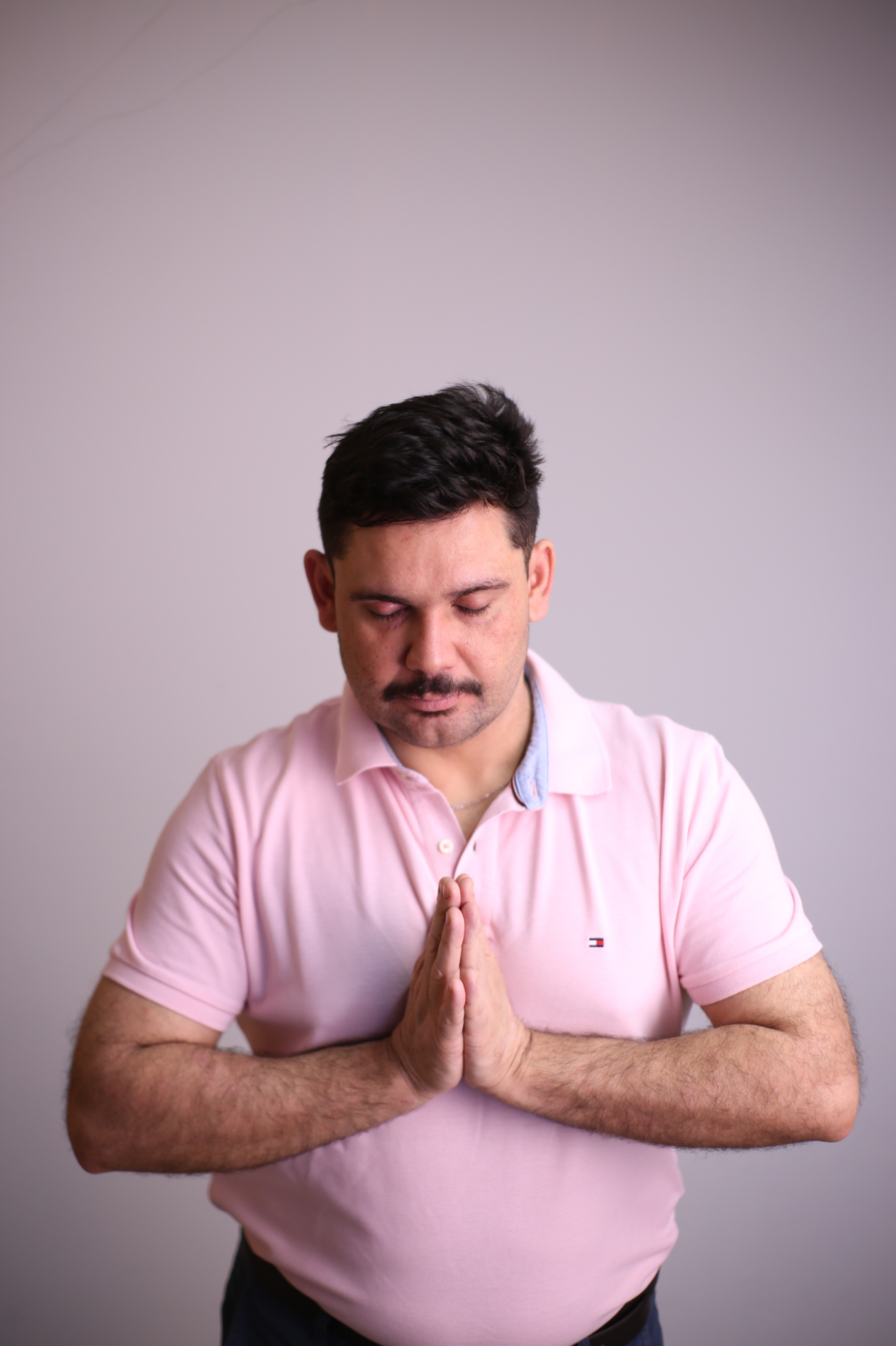 Caio com as mãos unidas em gratidão