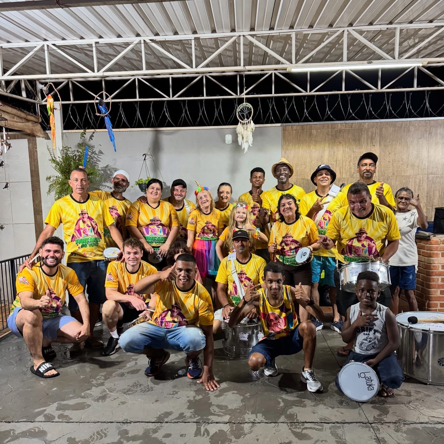 Integrantes da Fanfarra do Vovô Anésio de camisa amarela em um salão